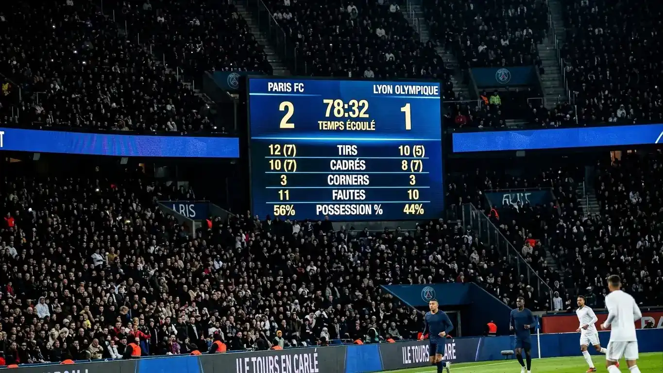 Un tableau d'affichage de stade illuminé affichant des statistiques de match, foule en arrière-plan